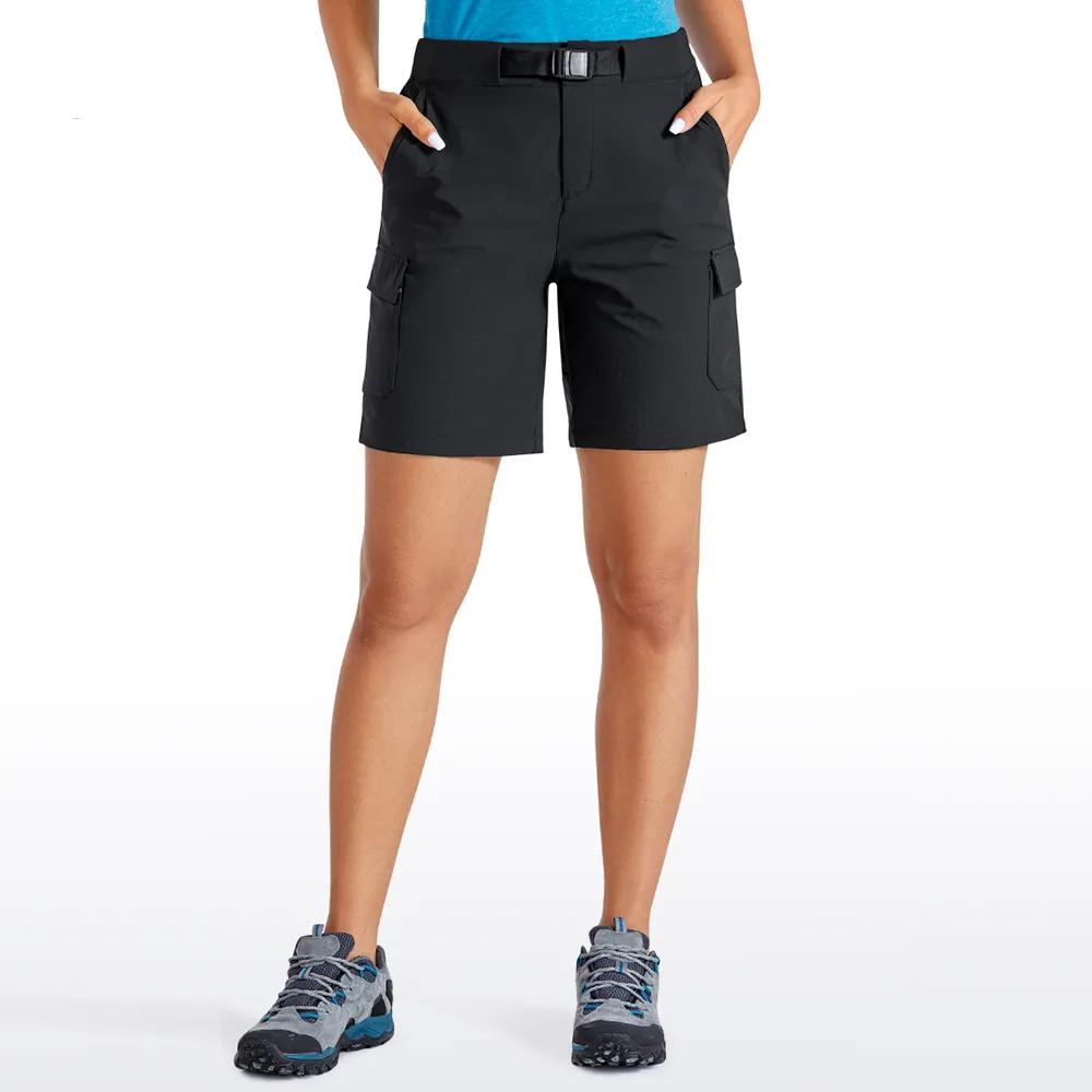Femme portant un bermuda noir et des chaussures noires sur un fond blanc.