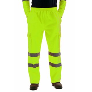 On voit une paire de jambes habillée d'un pantalon de haute visibilité jaune fluo avec des bandes réfléchissantes sur les genoux.