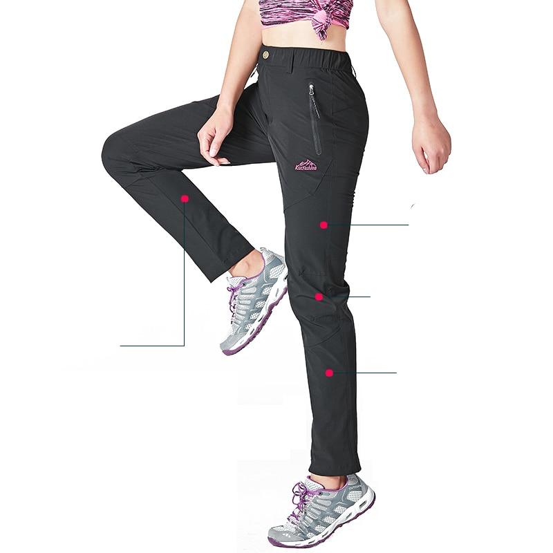 Femme portant un pantalon de travail noir sur un fond blanc.