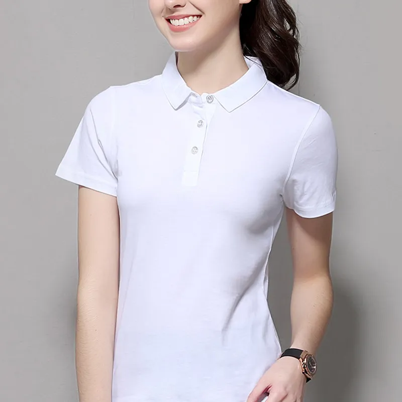 Femme portant un polo blanc sur fond gris.