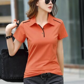 Femme portant un polo orange et tenant un sac dans sa main.