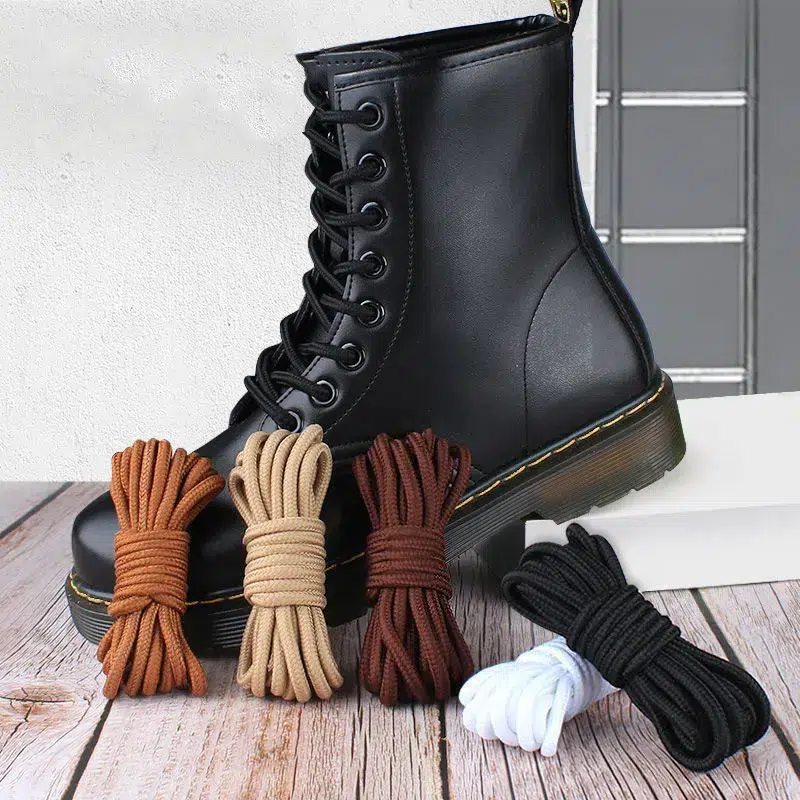Chaussure noire avec des lacets pliés de plusieurs couleurs posés devant