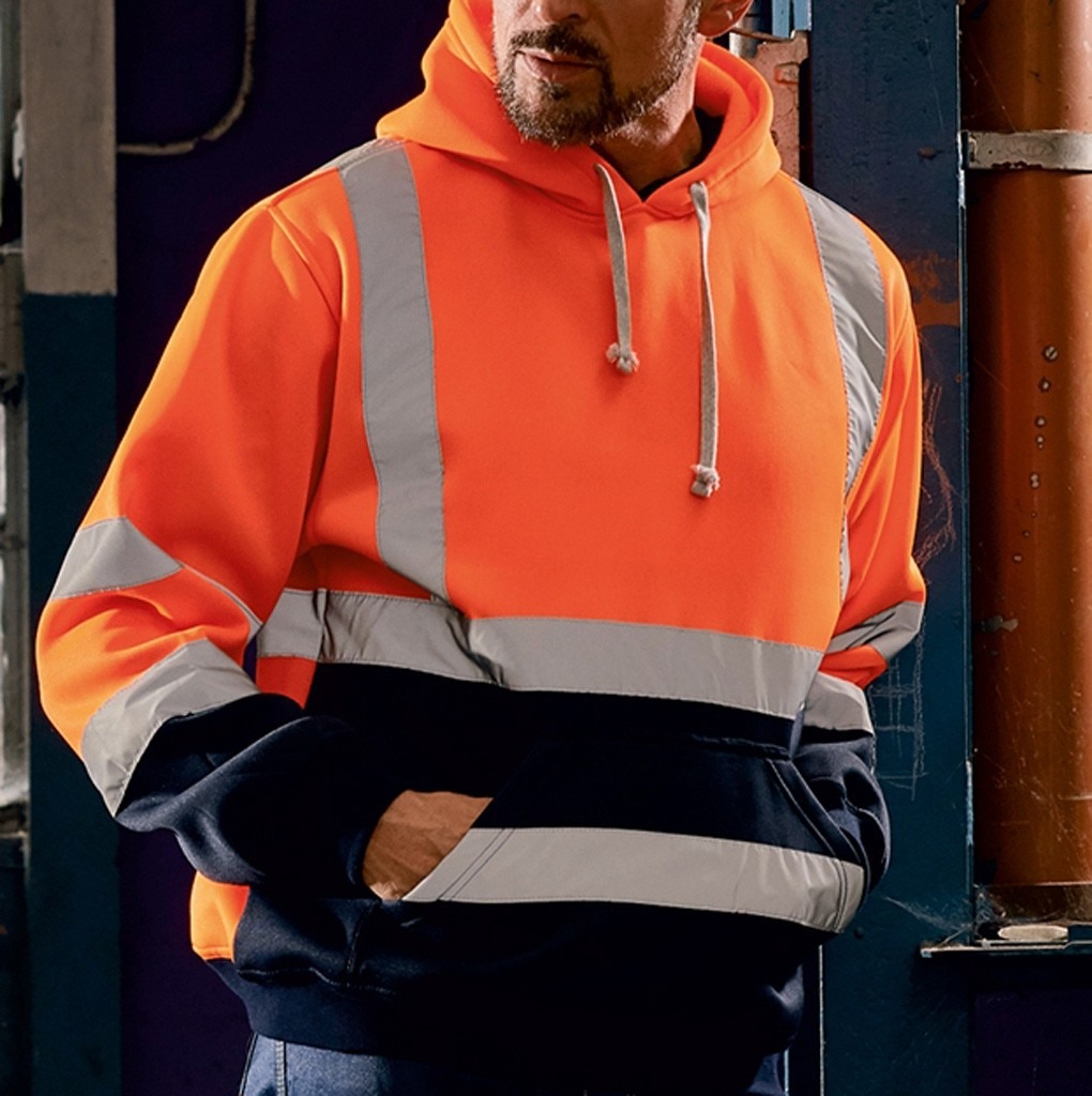 On voit un homme qui porte un sweat haute visibilité orange et noir avec des bandes réfléchissantes.