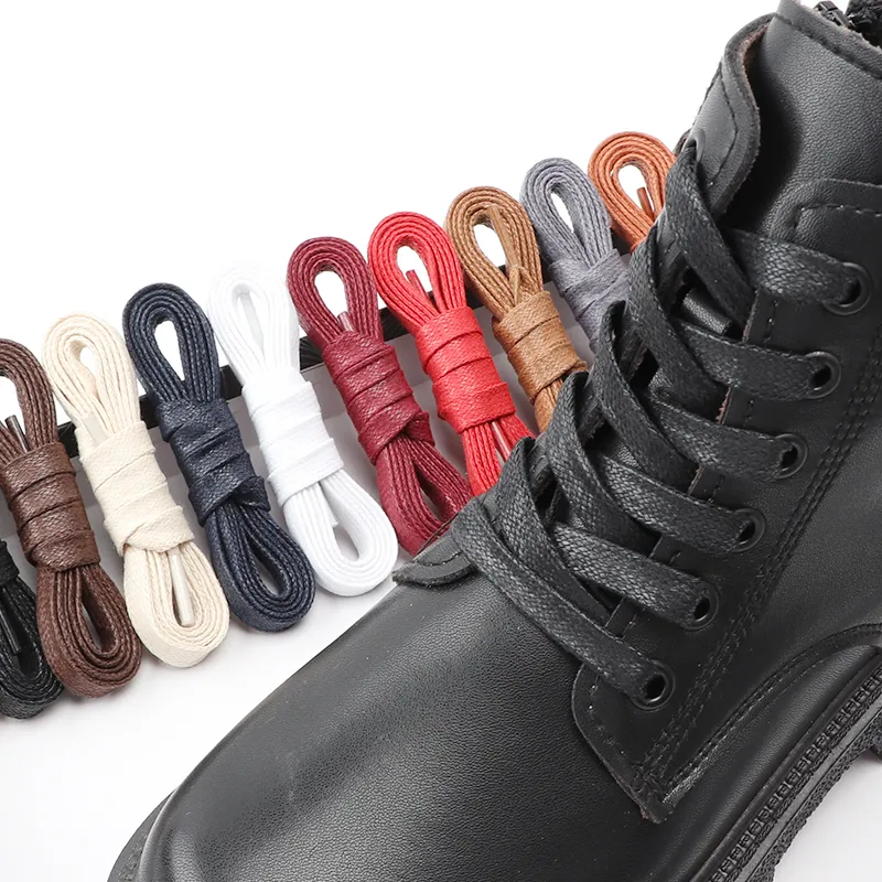 Chaussure noire avec des lacets noirs et des lacets enroulés de couleur enroulés posés les uns après les autres
