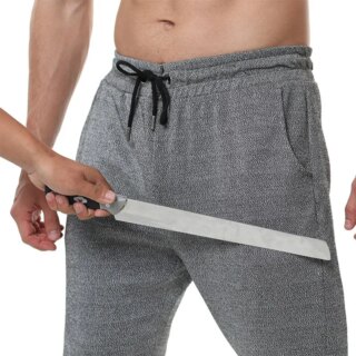 Photo d'un pantalon anti coupure style jogging avec une main tenant un couteau devant