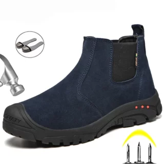 On voit une chaussure de sécurité style chelsea, montante et sans lacets, en suédine bleu marine. Elle est anti-écrasement et anti-perforation.