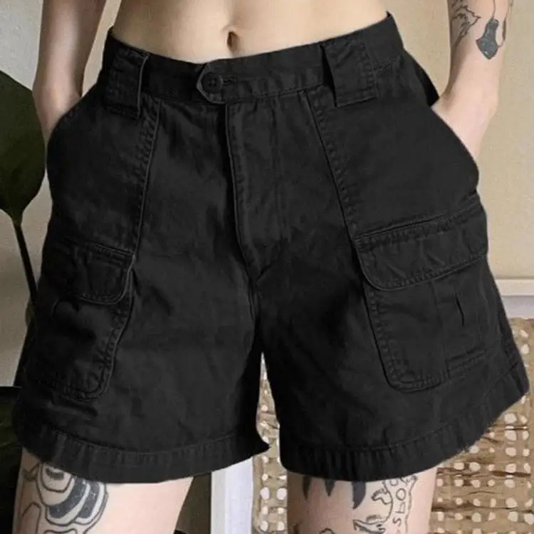 Bermuda de travail femme style cargo noir taille haute, porté par une femme avec les mains dans les poches.