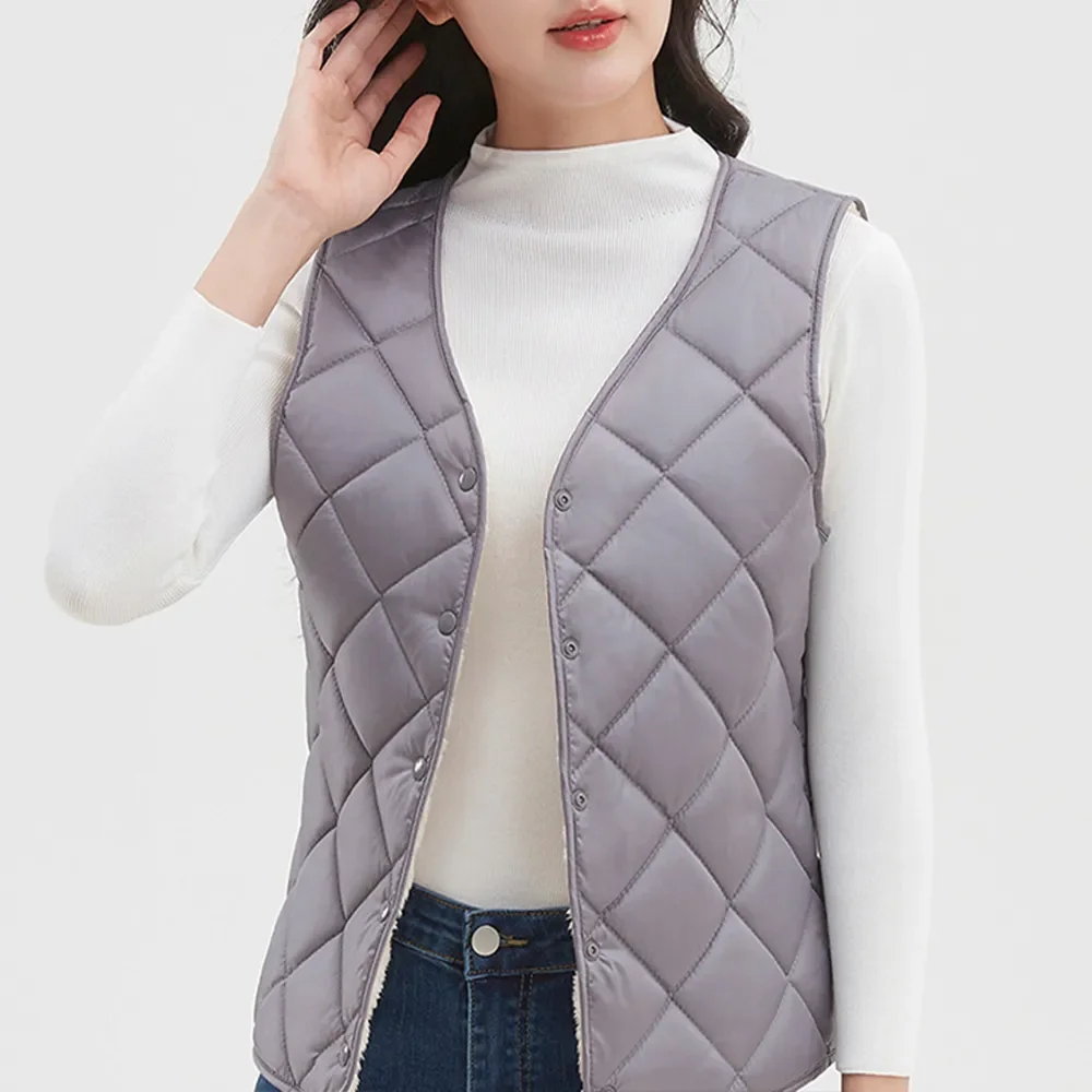 Veste de travail femme sans manches rembourrée et classe portée par une femme sur fond gris